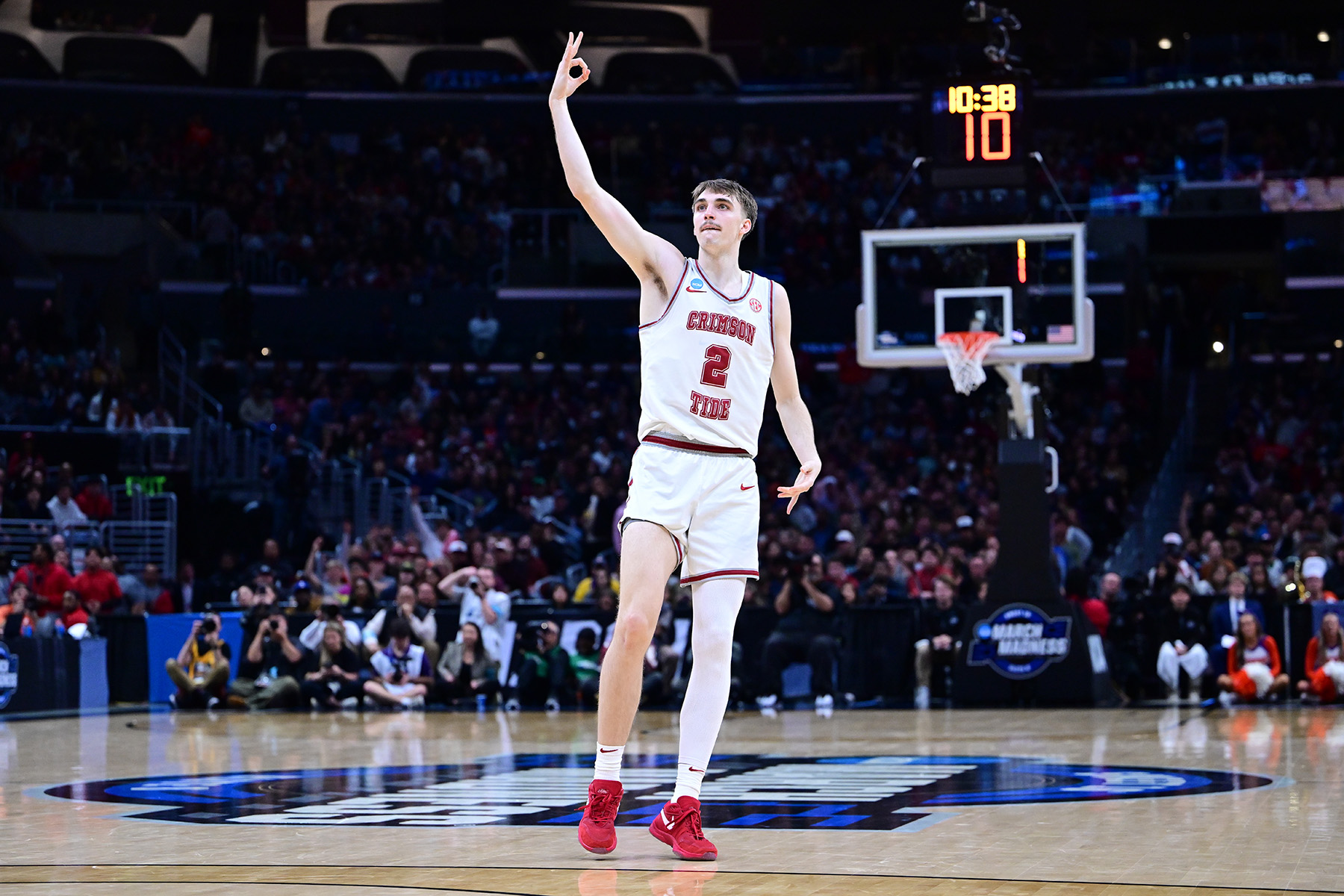 Alabama forward Grant Nelson raises his arm up to celebrate a made three-pointer.