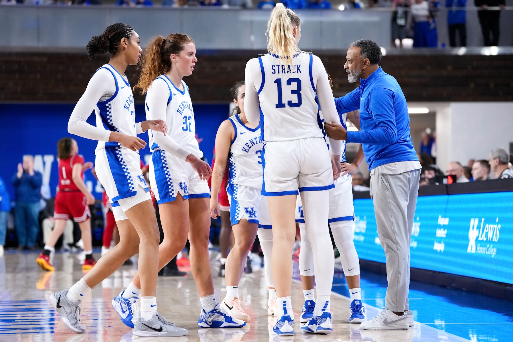 Head coach Kenny Brooks of the Kentucky Wildcats meets with his team in overtime against the Louisville Cardinals