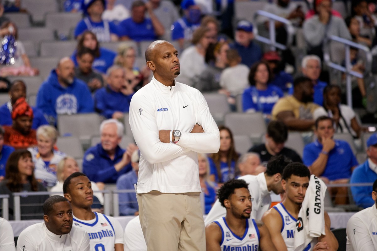 Memphis basketball coach Penny Hardway with his arms crossed on the sideline.