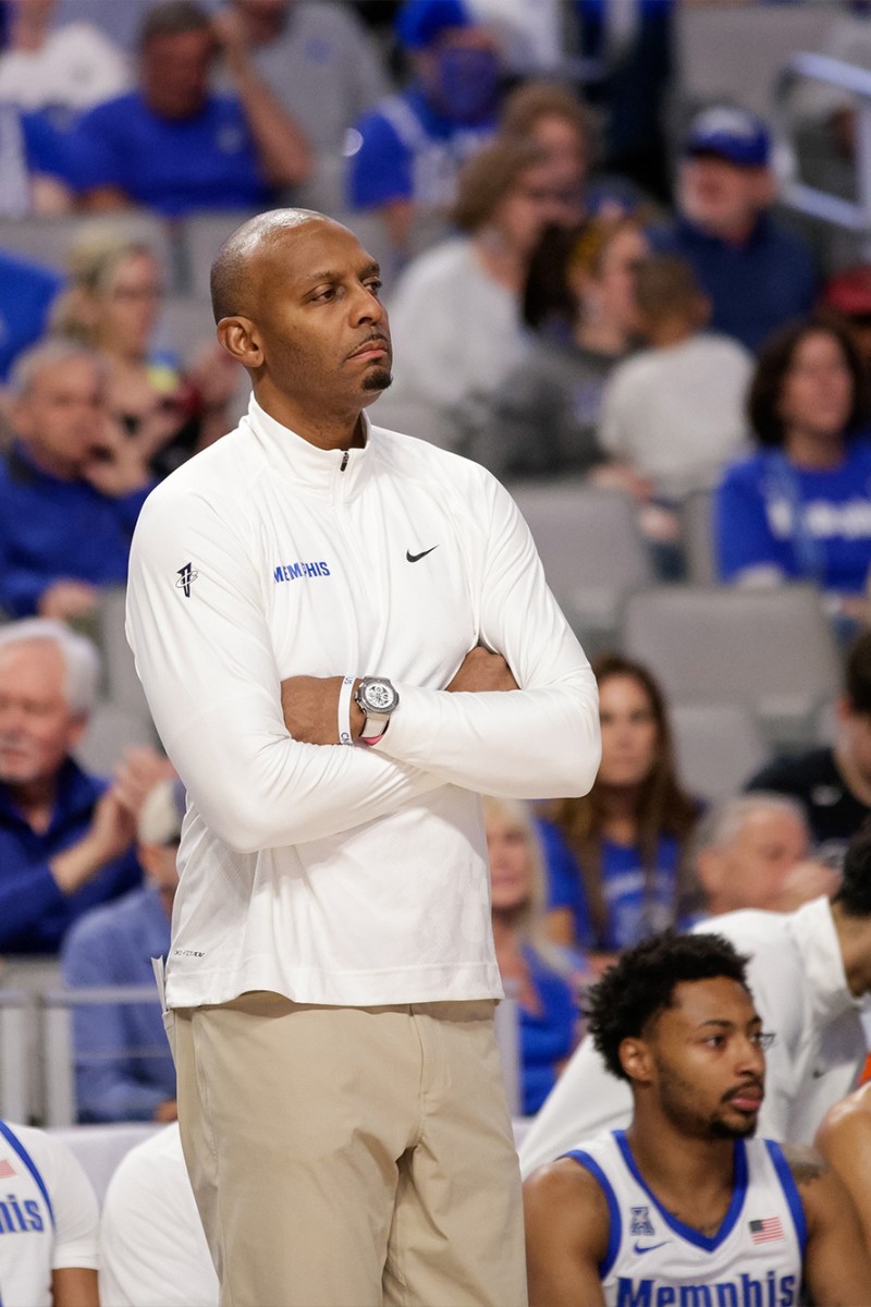 Memphis basketball coach Penny Hardway with his arms crossed on the sideline.
