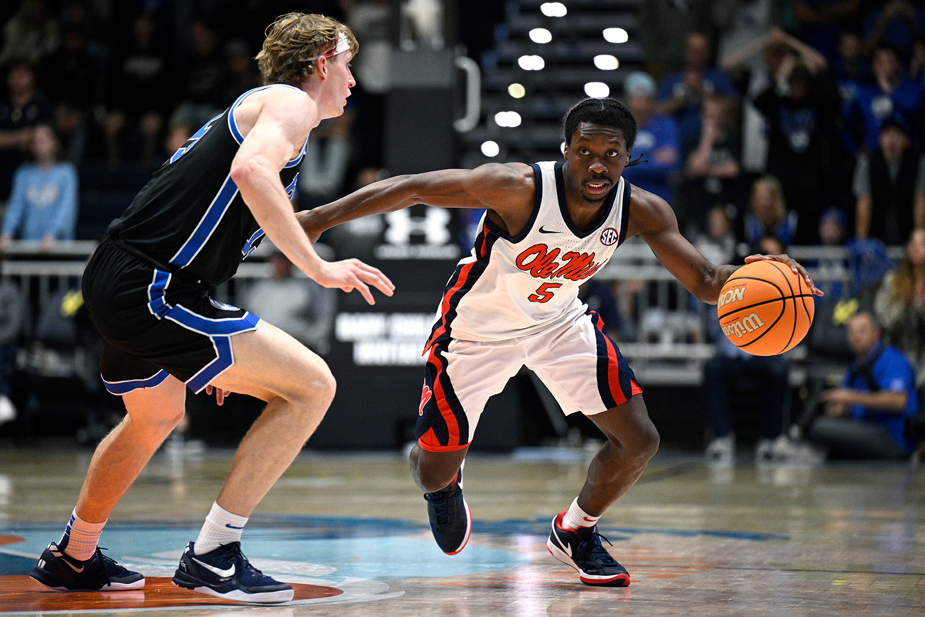 Ole Miss guard Jaylen Murray dribbles the ball with his left hand while being guarded by a defender.