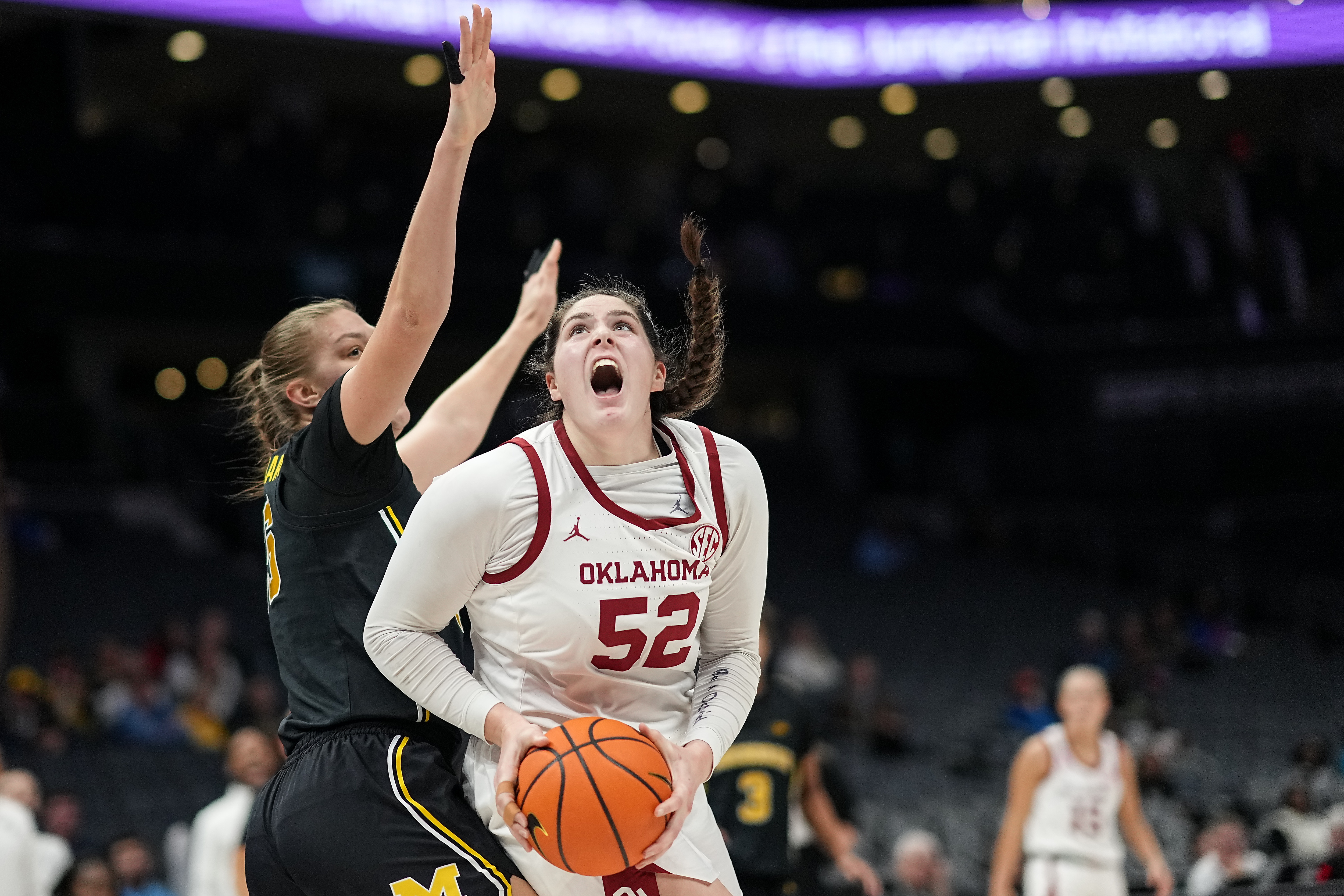 OKlahoma's Raegan Beers looking up towards the rim and seemingly screaming with a basketball in her hands against Michigan