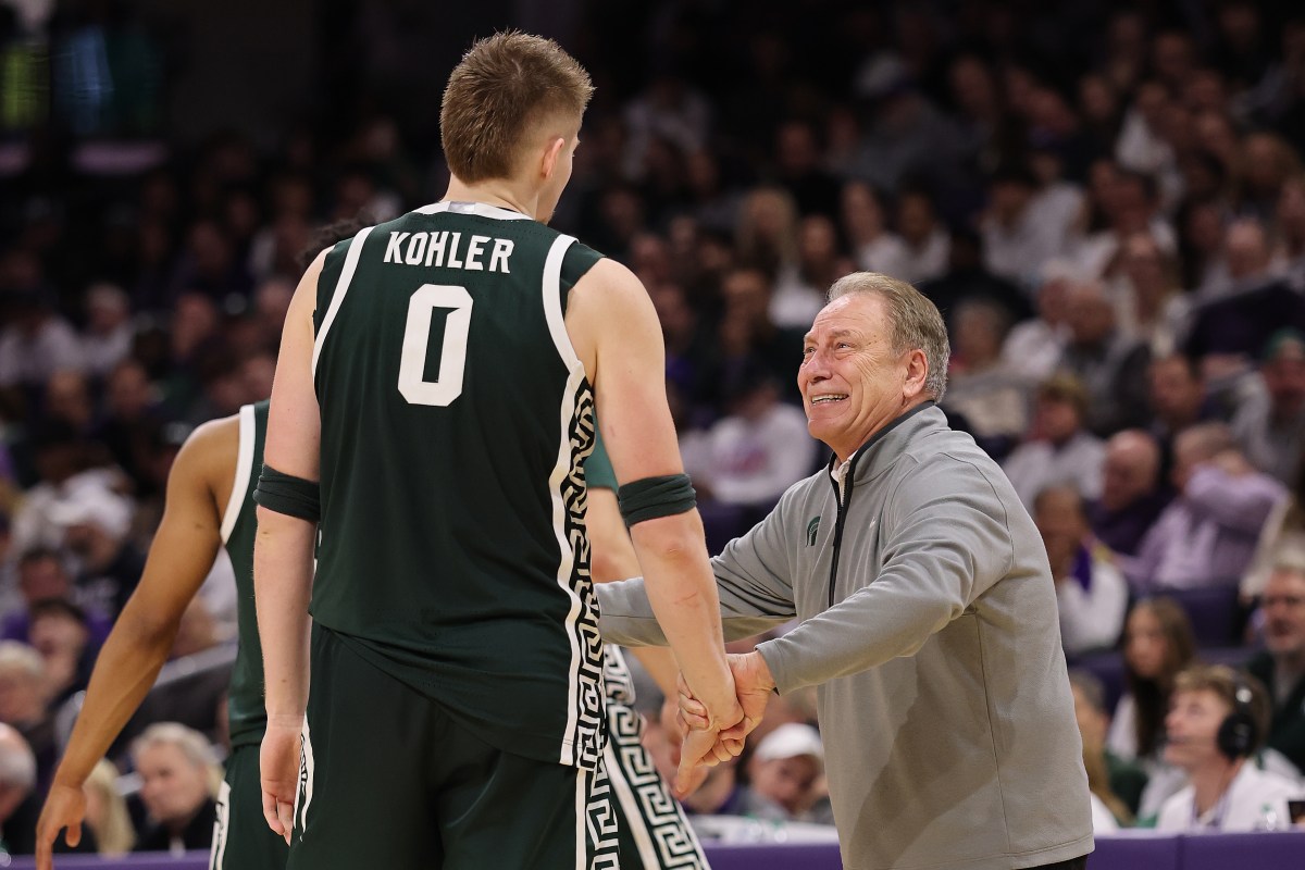 Michigan State coach Tom Izzo smiles and reaches out to hug one of his players