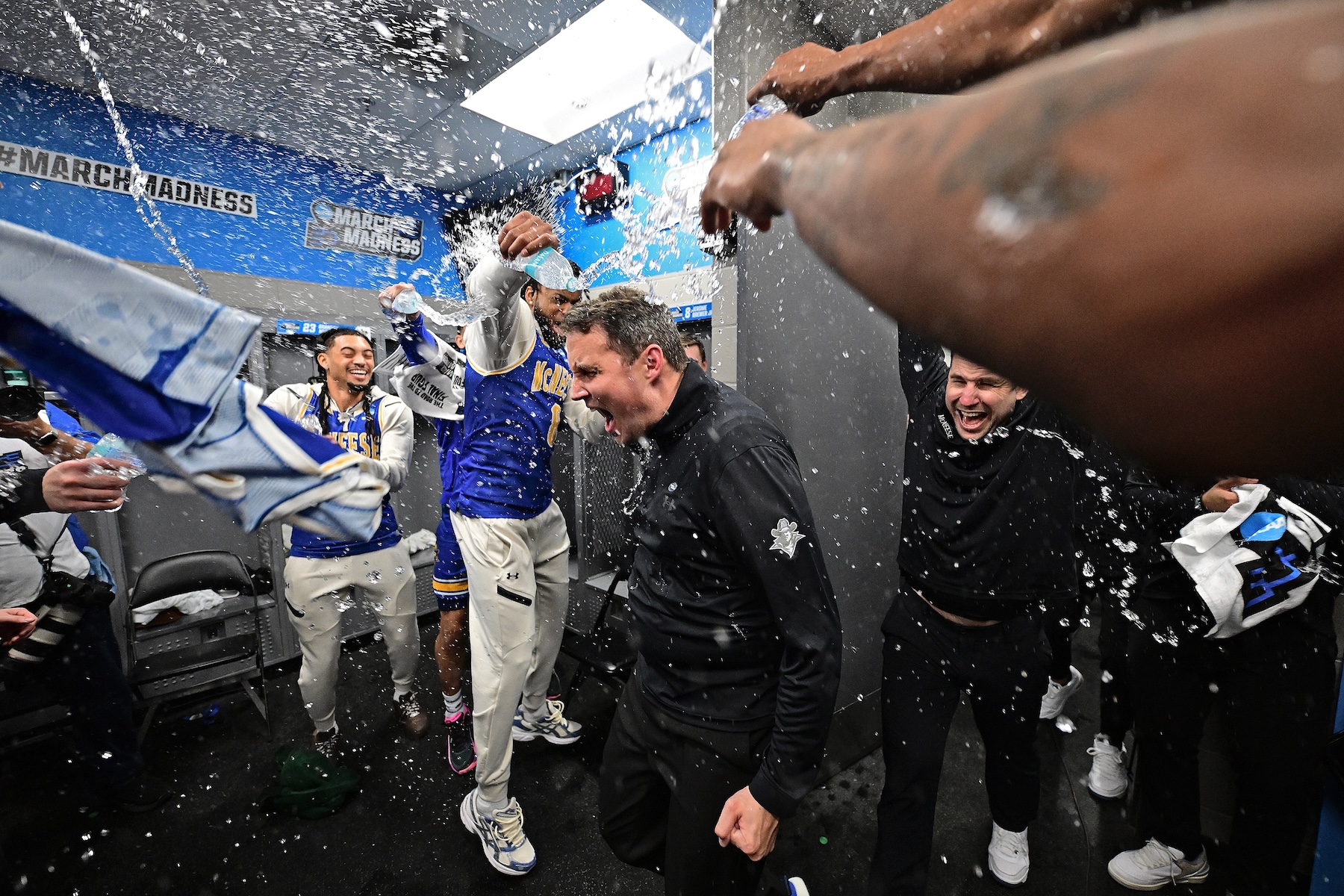 McNeese Cowboys players shower head coach Will Wade to  celebrates the team’s win over Clemson