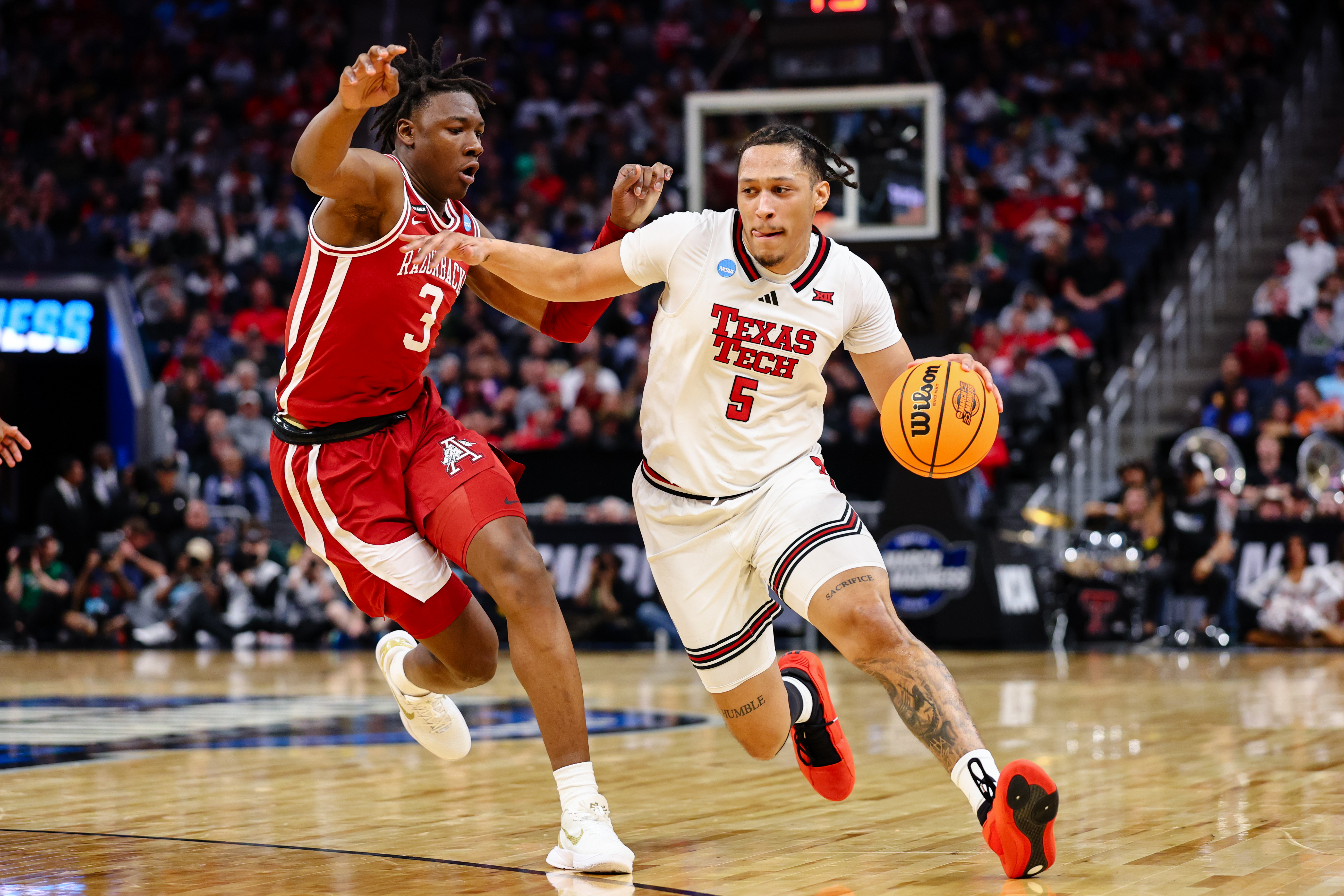 Darrion Williams #5 of the Texas Tech Red Raiders drives past Adou Thiero #3 of the Arkansas Razorbacks during the Sweet Sixteen round of the 2025 NCAA Men's Basketball Tournament held at Chase Center on March 27, 2025 in San Francisco, California.