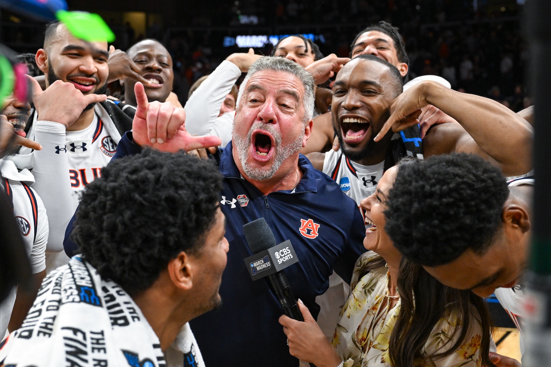 Auburn head coach Bruce Pearl and players celebrate during an interview with CBS reporter Tracy Wolfson
