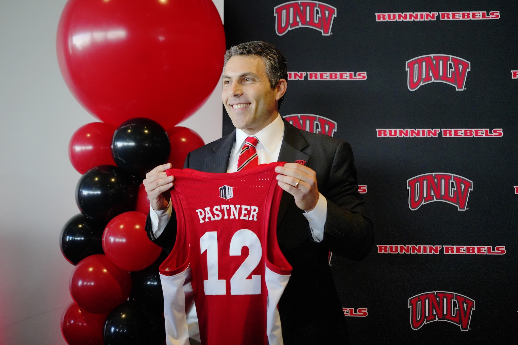 Josh Pastner poses with his new jersey