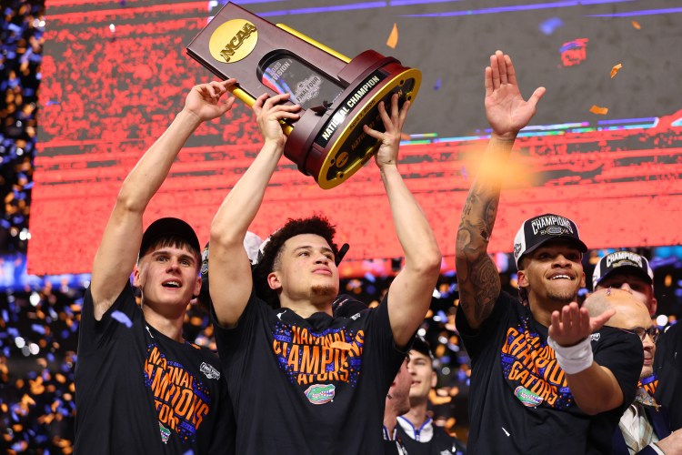 Walter Clayton Jr. and his teammates celebrate with the championship trophy as confetti rains down on April 07, 2025