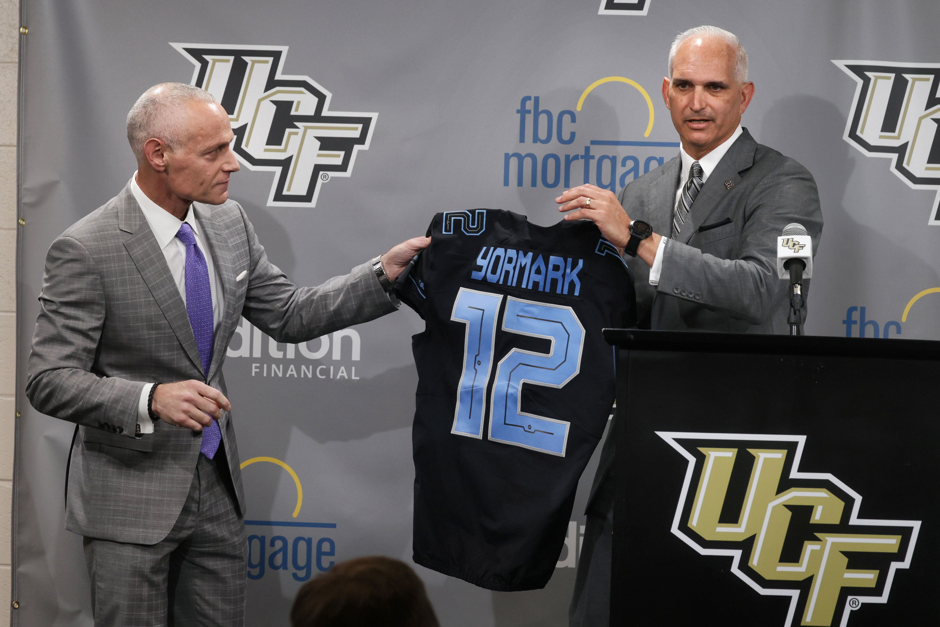 Commissioner Yormark is presented with a custom jersey by UCF athletic director Terry Mohajir