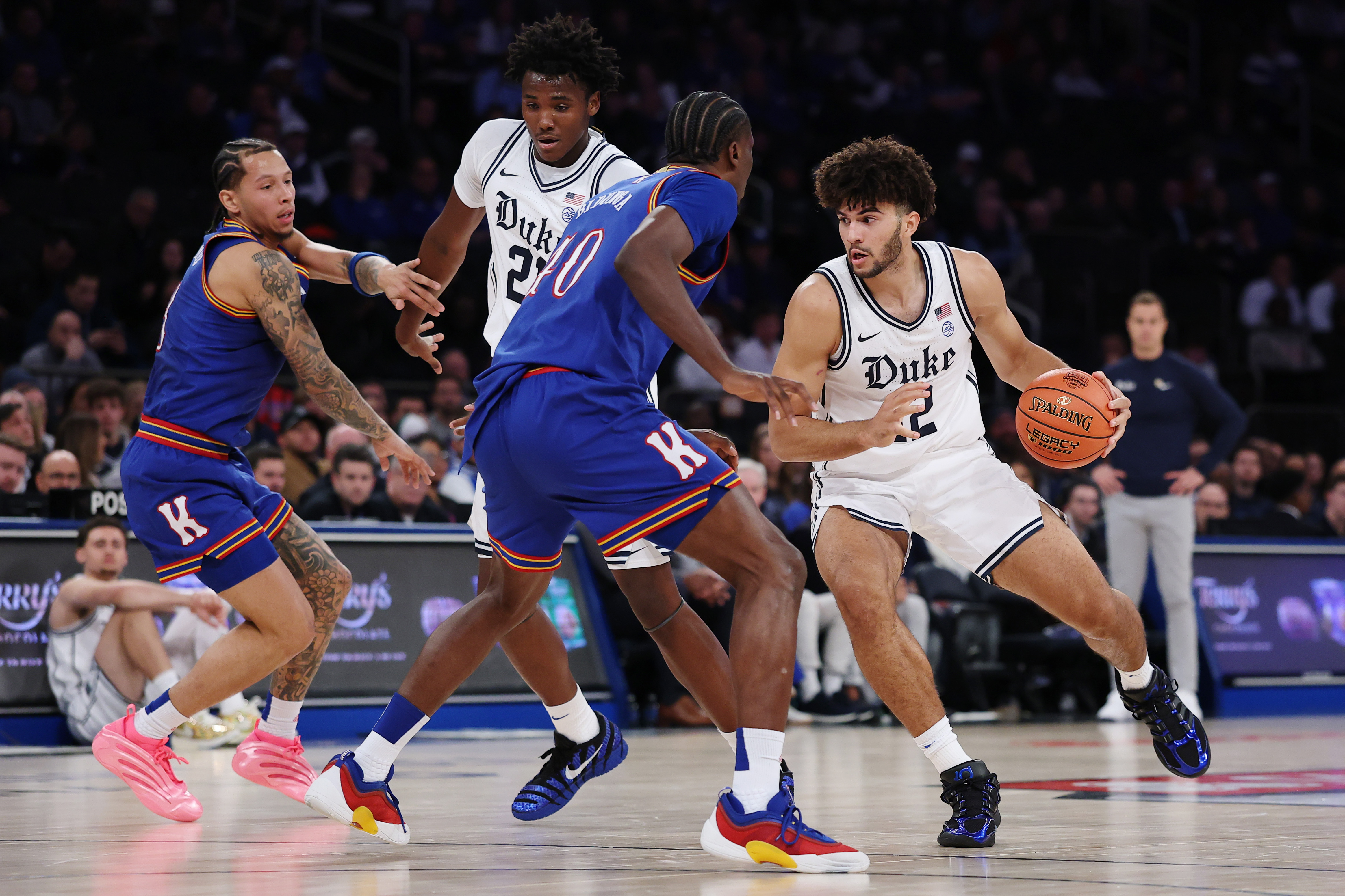 Cameron Boozer #12 of the Duke Blue Devils dribbles against Flory Bidunga #40 of the Kansas Jayhawks