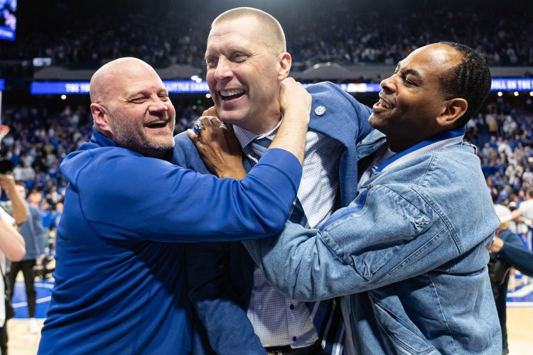 Mark Pope celebrates with members of his 1996 Championship team after the Wildcats' win over Tennessee on Saturday