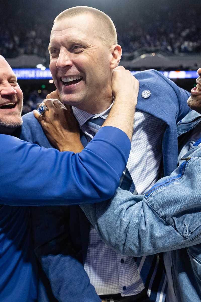 Mark Pope celebrates with members of his 1996 Championship team after the Wildcats' win over Tennessee on Saturday