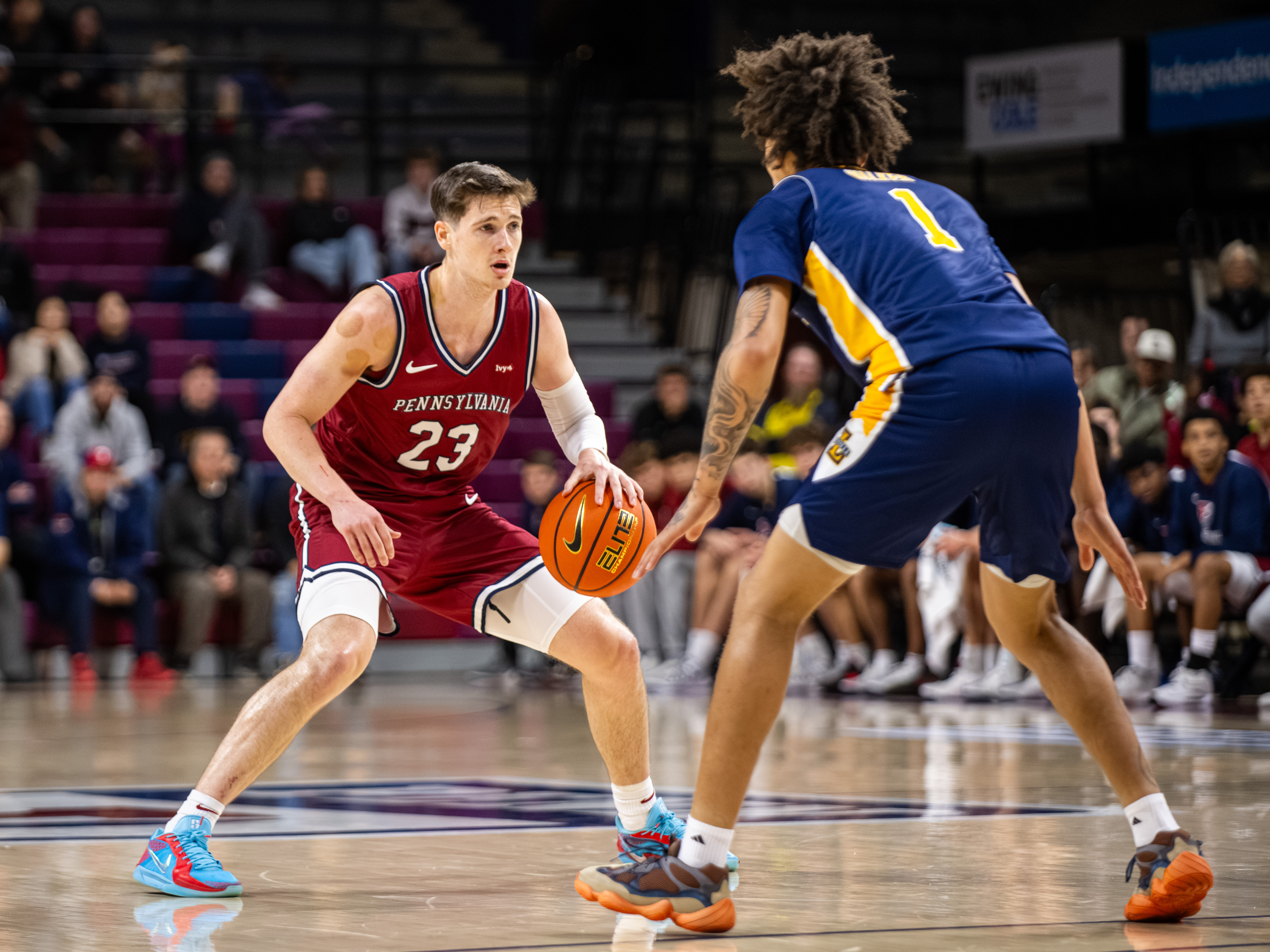 Basketball player Ethan Roberts of Penn dribbles up the court