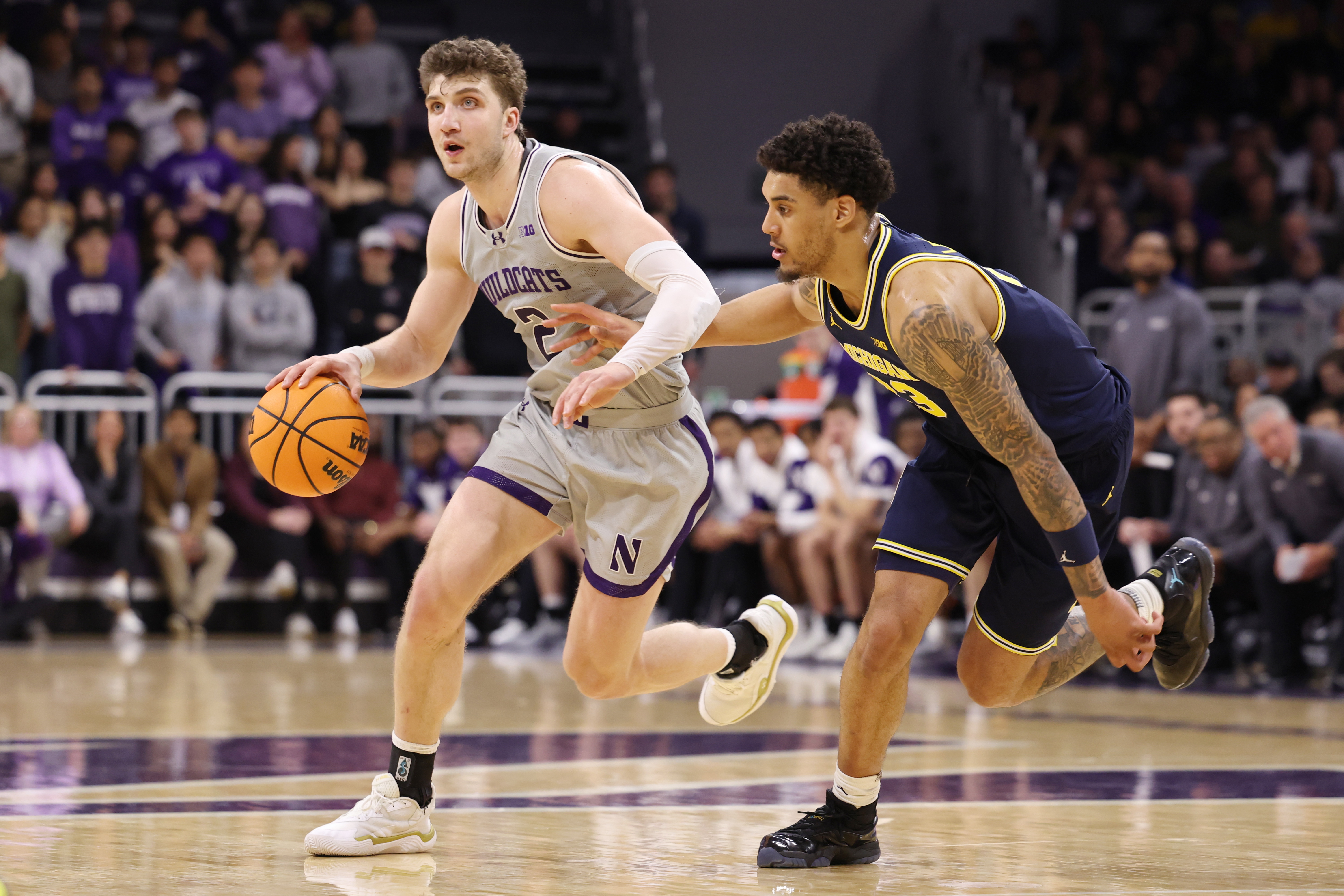 Martinelli dribbling past Michigan star Yaxel Lendeborg during a Northwestern loss on Feb. 11