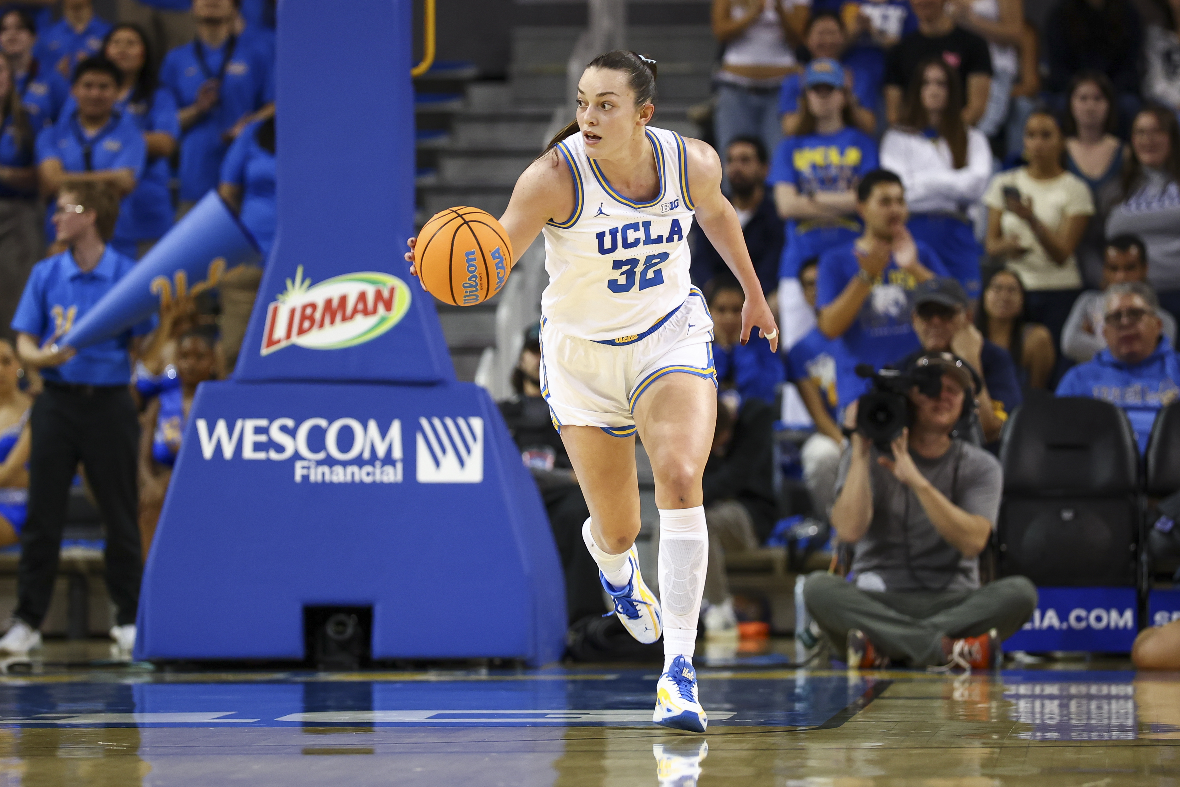 UCLA Bruins basketball player Angela Dugalić dribbles up the court