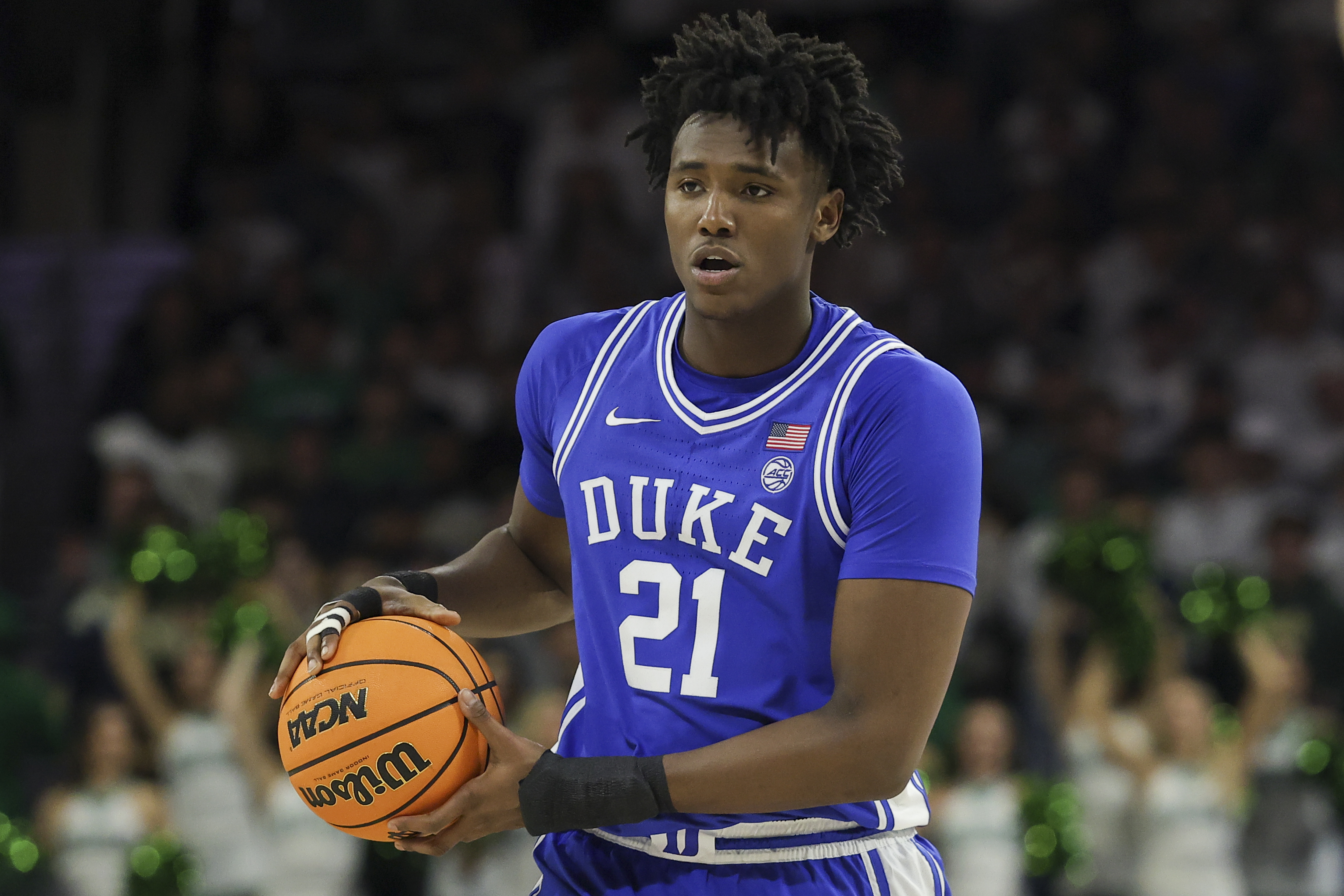 Duke center Patrick Ngongba dribbles a basketball in his road blue uniform