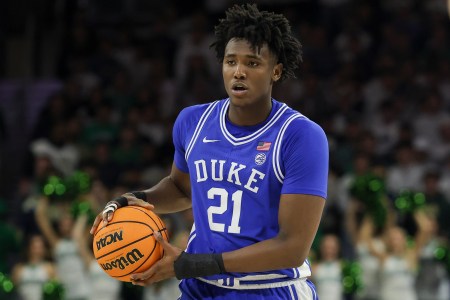 Duke center Patrick Ngongba dribbles a basketball in his road blue uniform