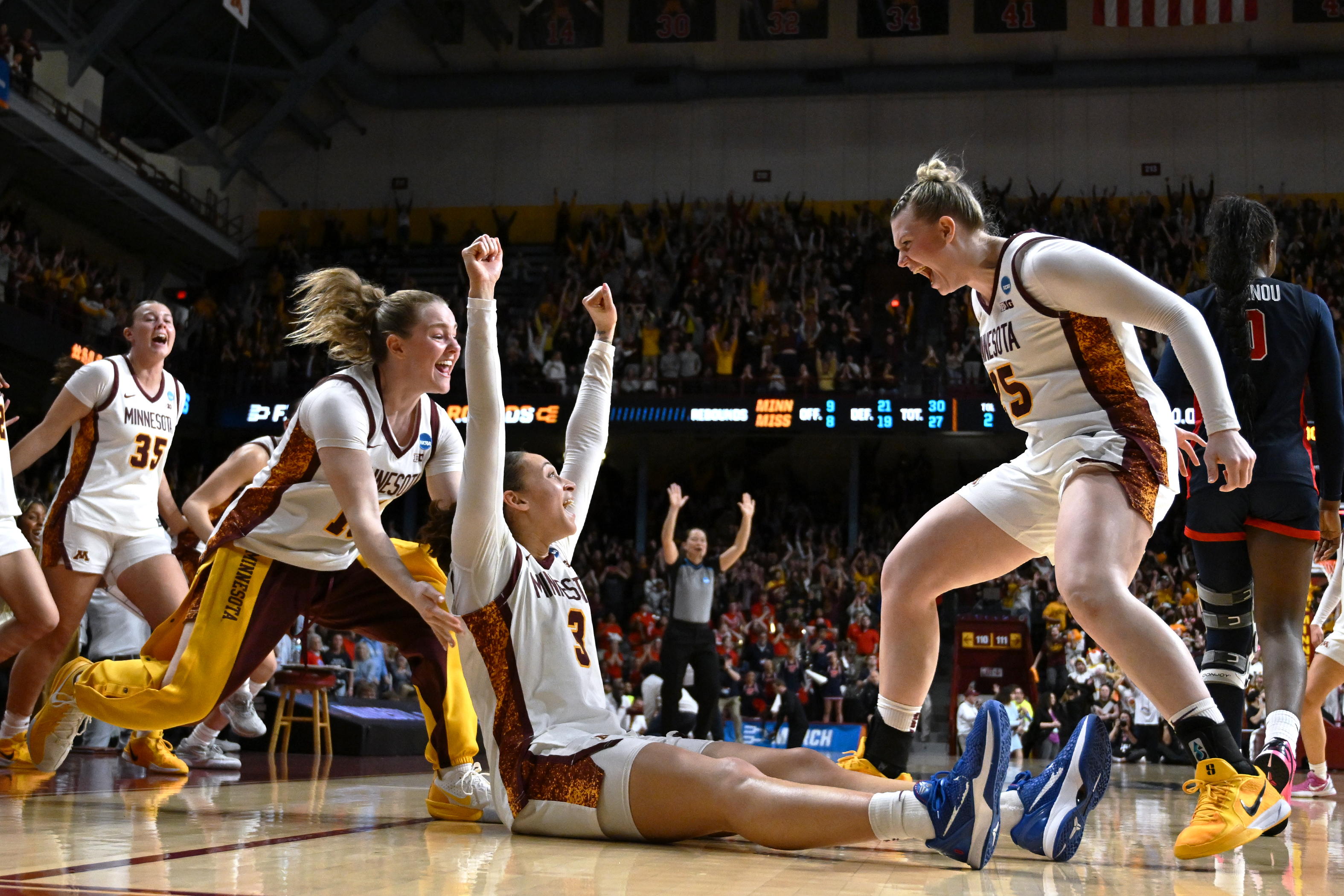 Golden Gophers guard Amaya Battle (seated) gets swarmed by teammates after hitting the game-winning shot over Ole Miss