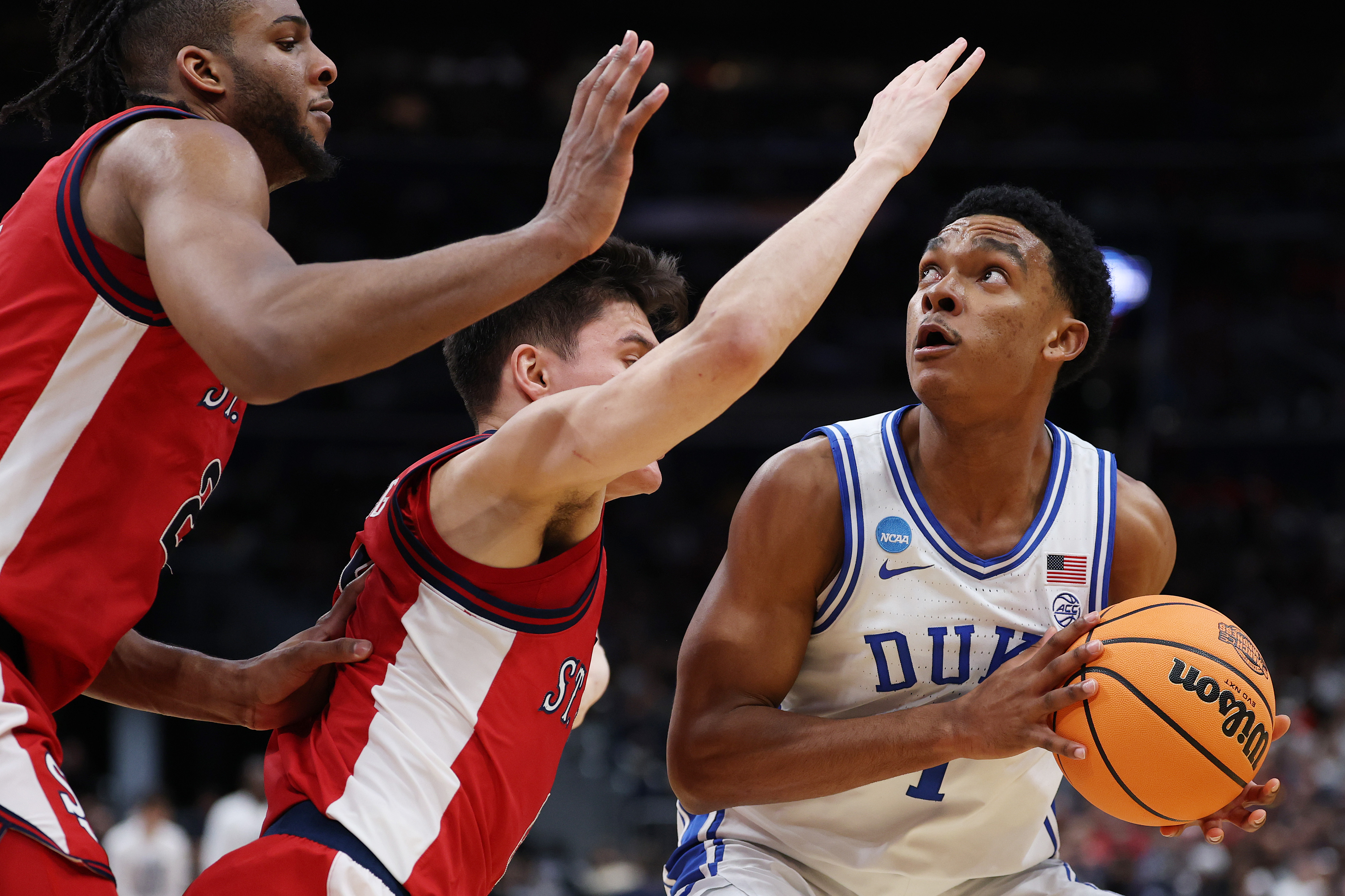 Duke University basketball player Caleb Foster goes up for a shot against two St. John's defenders