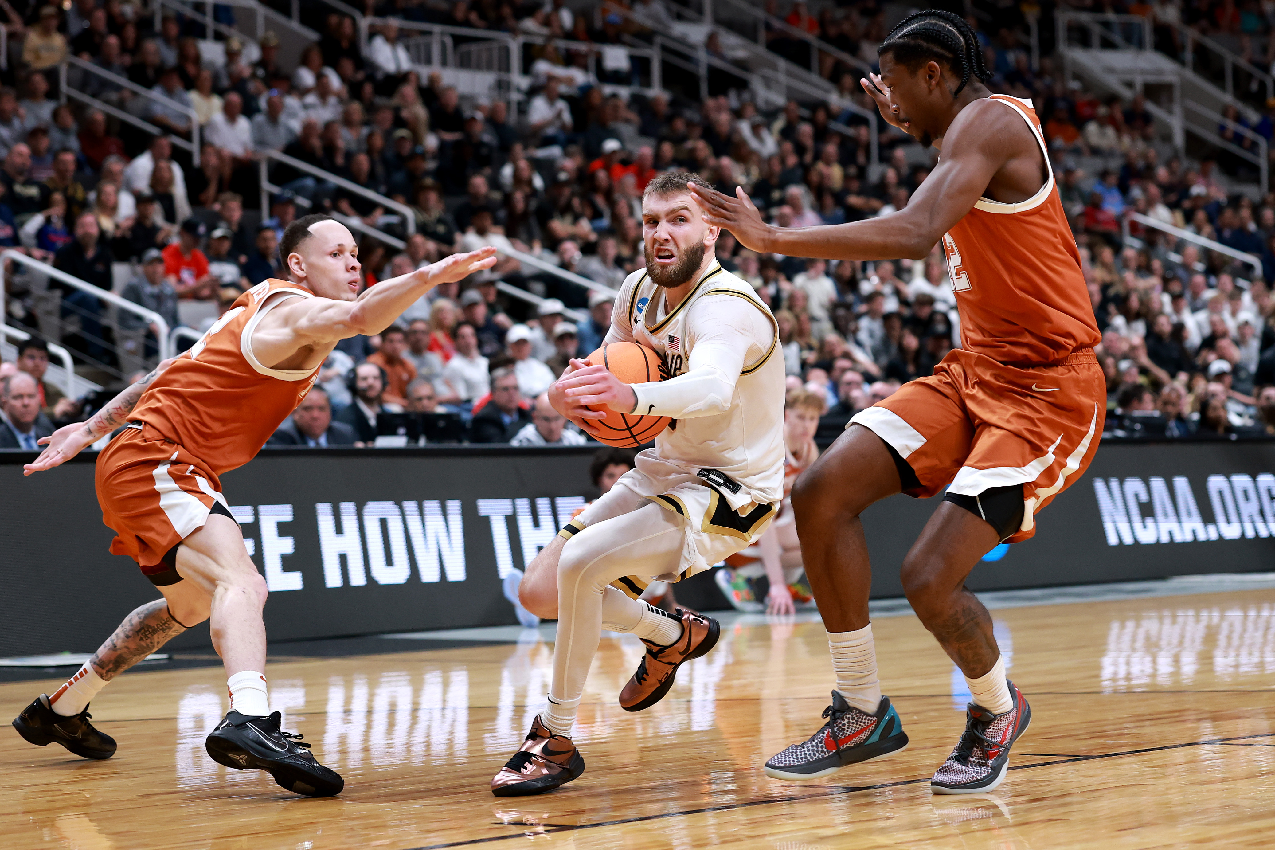 Purdue's Braden Smith dribbes through Tramon Mark and Chendall Weaver of the Texas Longhorns