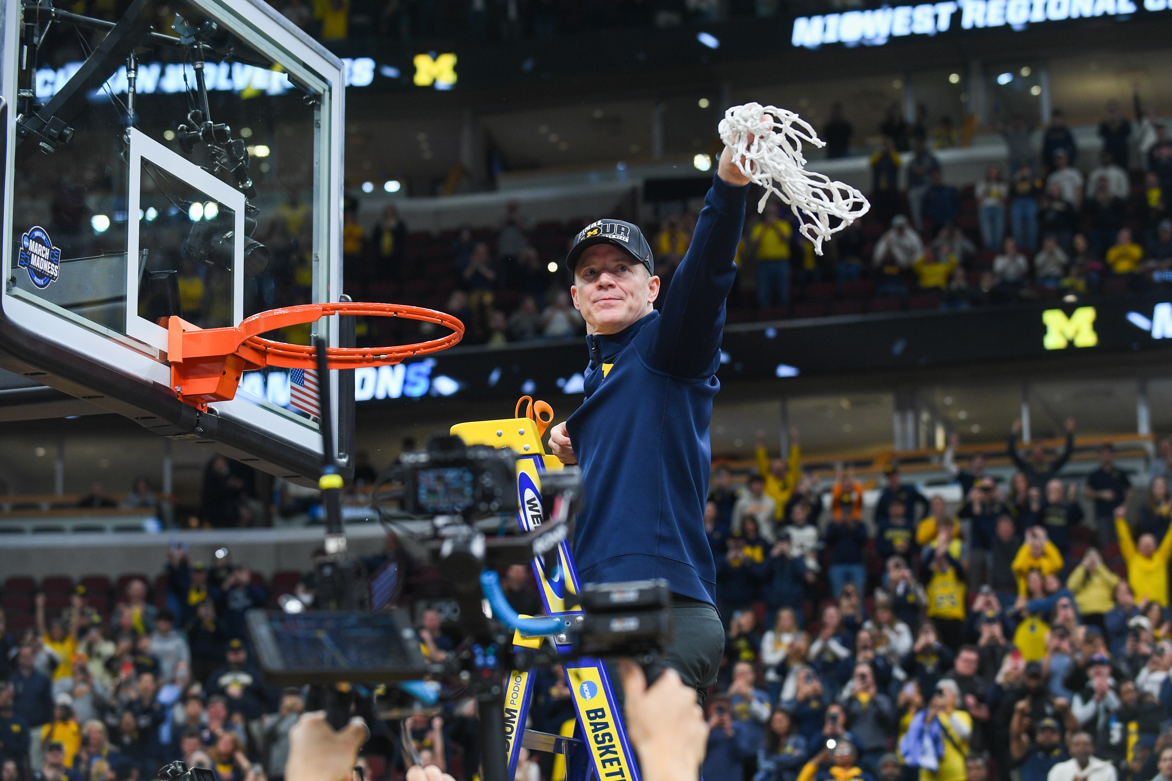 Michigan coach Dusty May cuts down the net after beating Tennessee in the Elite Eight