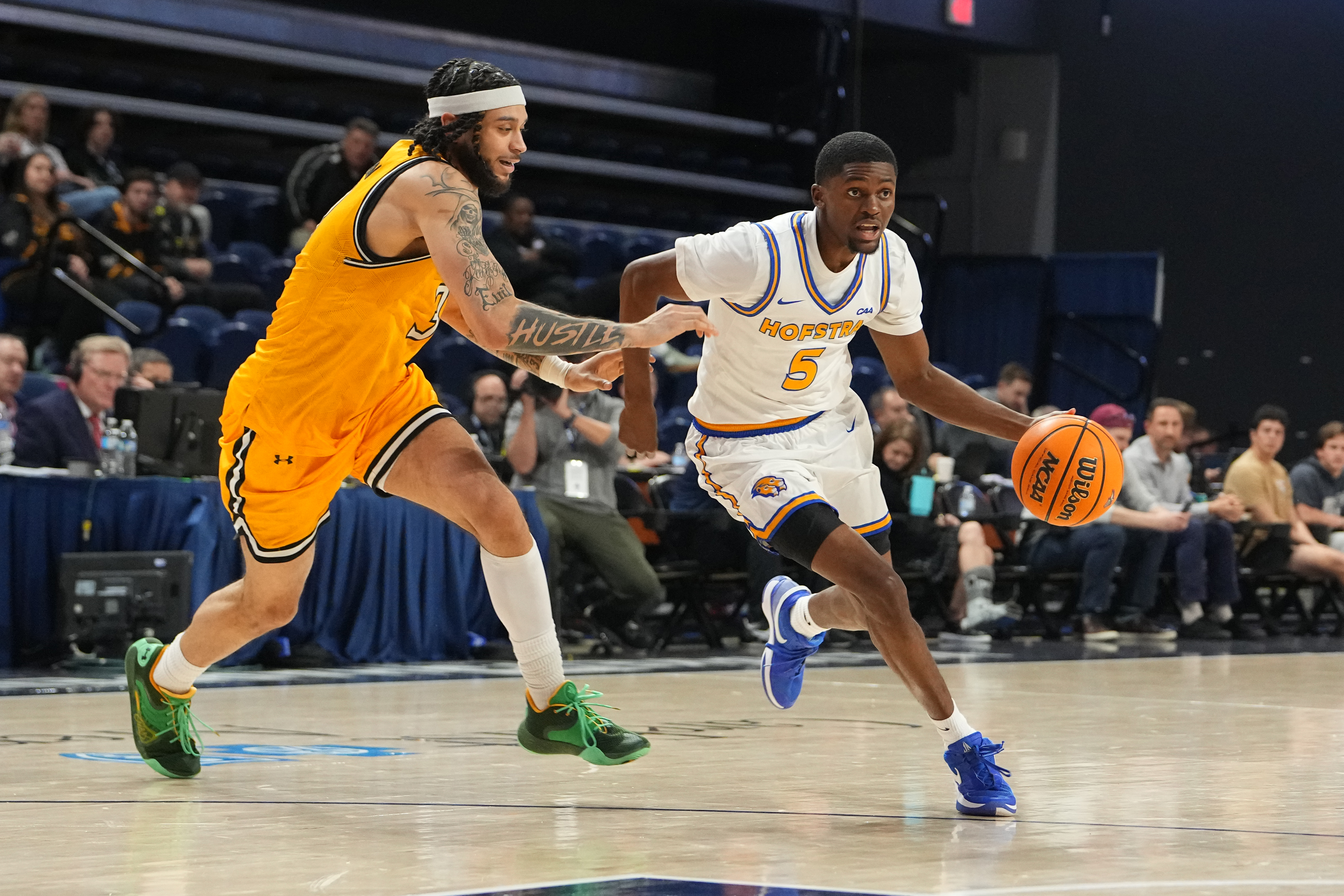 Hofstra guard Cruz Davis dribbles past a Towson defender during a 2026 game