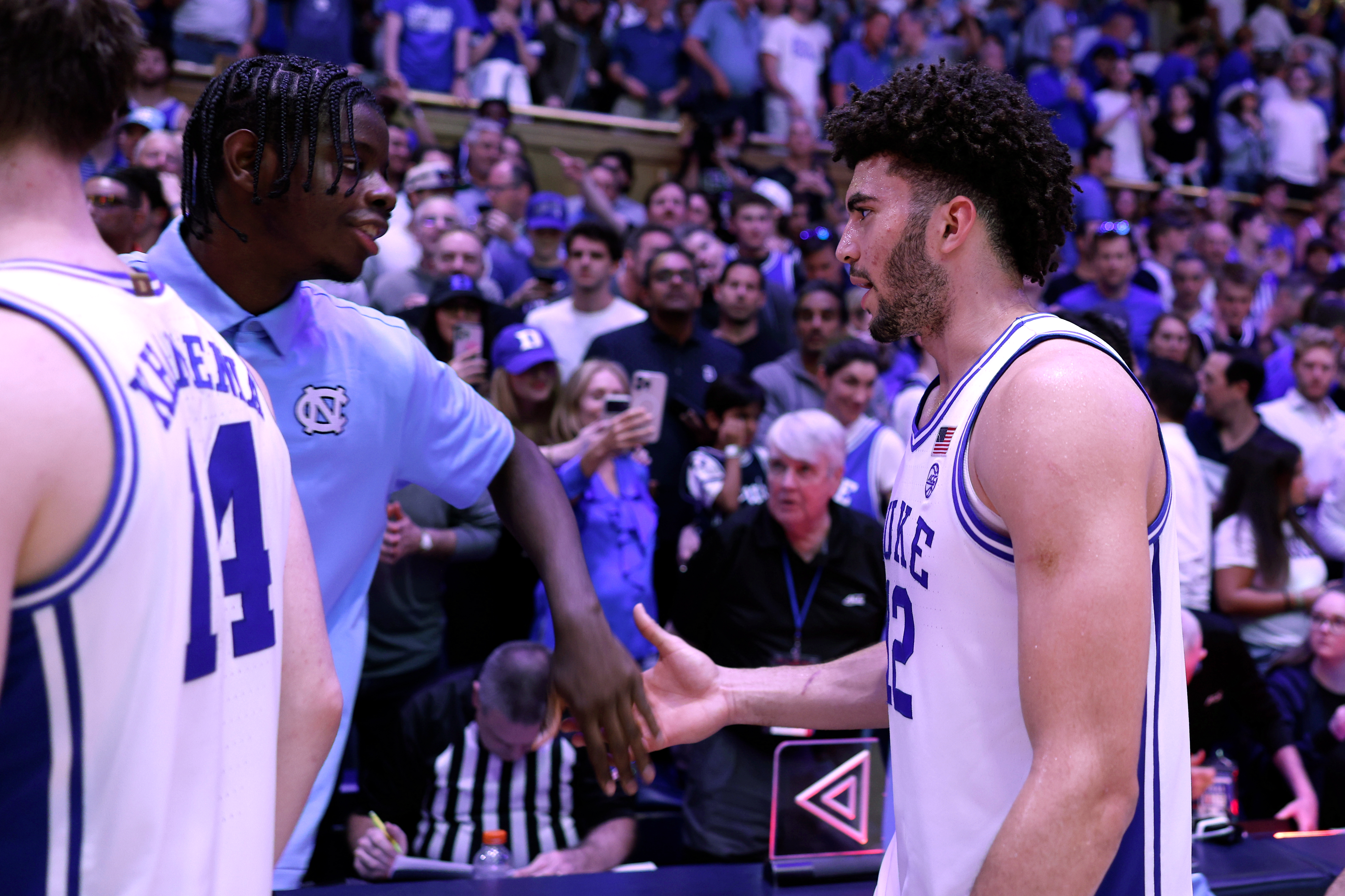 Wilson and Boozer shaking hands after a Duke win. Wilson missed the game while recovering from a season-ending hand injury.