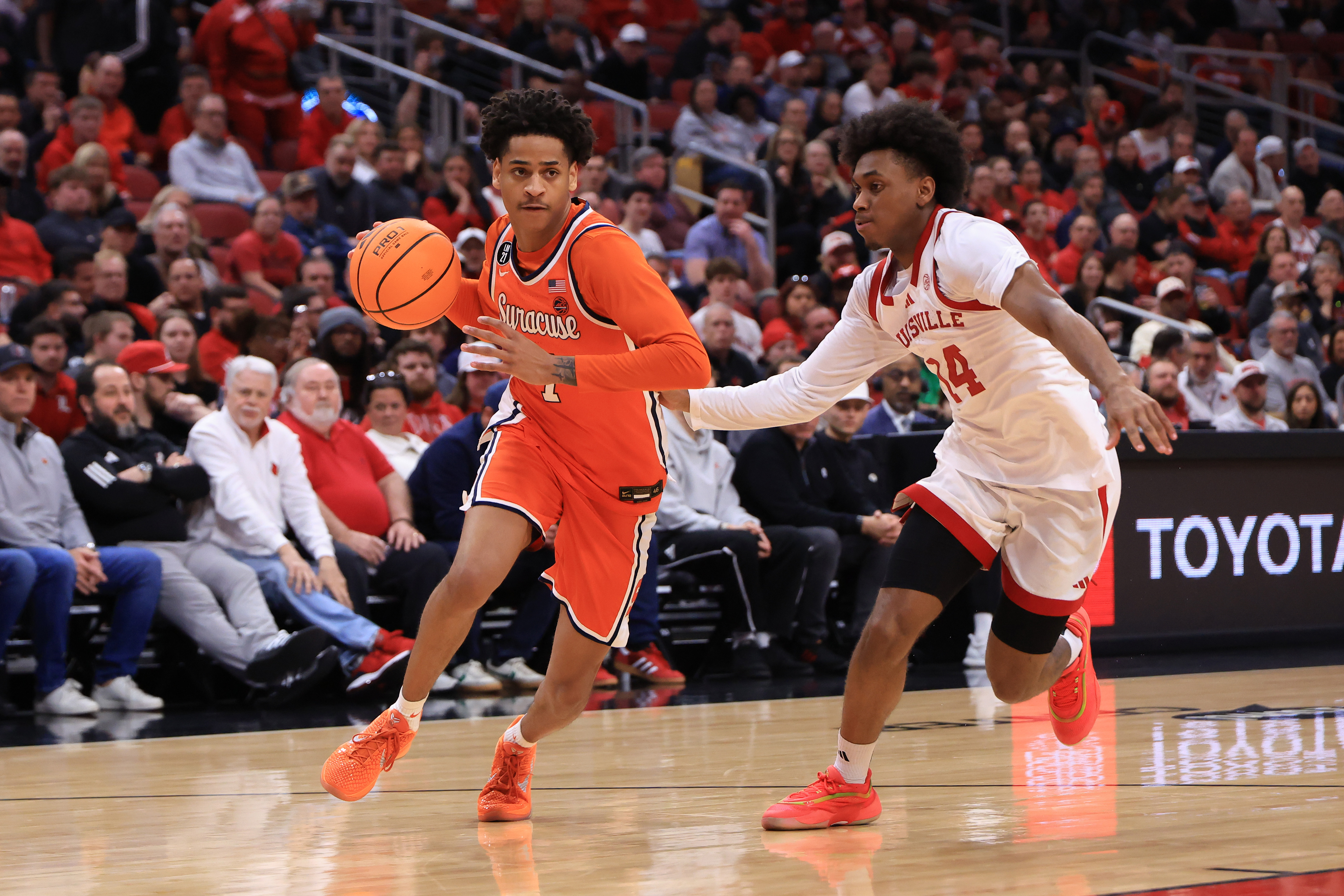 Kiyan Anthony of Syracuse drives to the basket against Adrian Wooley of Louisville in a 2026 game