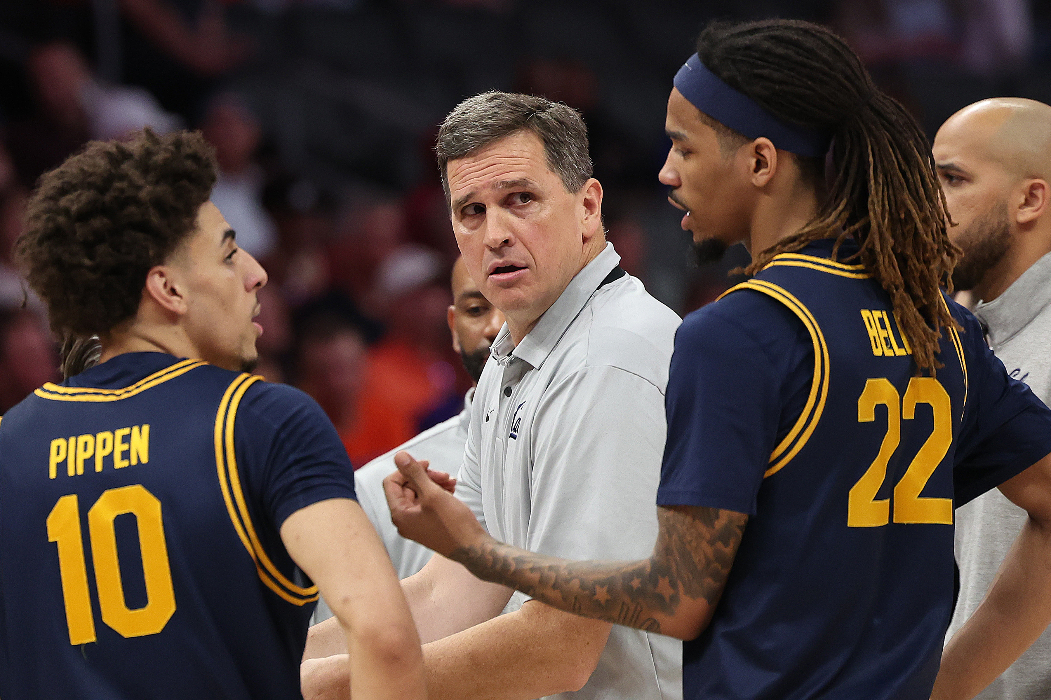 Madsen looks on as two of his players — Justin Pippen and Chris Bell — discuss strategy during a timeout in a 2026 ACC Tournament game