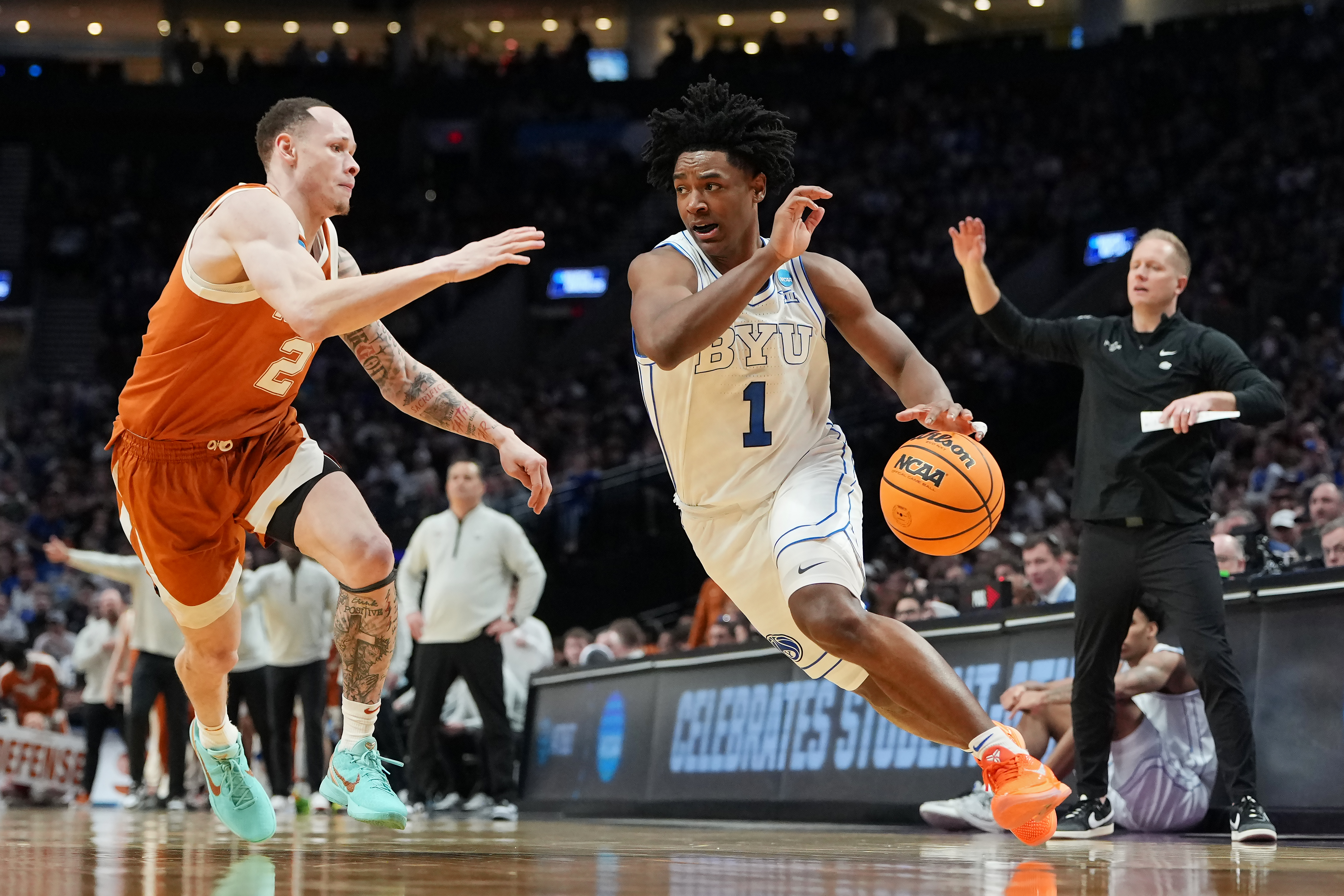BYU's Robert Wright III driving to the net while being guarded by Chendall Weaver of the Texas Longhorns