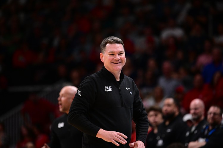 Arizona head coach Tommy Lloyd flashes a smile from the sidelines during a 2026 NCAA Tournament game