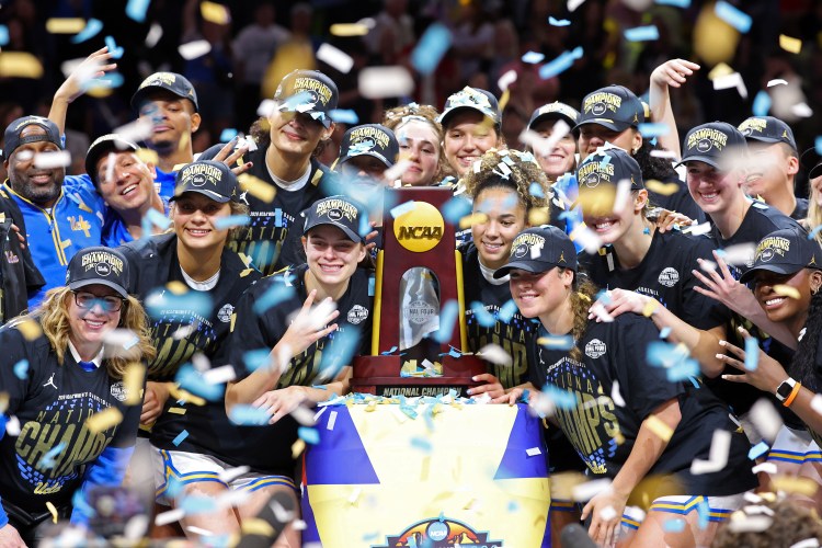 UCLA women's basketball team posing with their trophy after defeating South Carolina in the 2026 National Title game