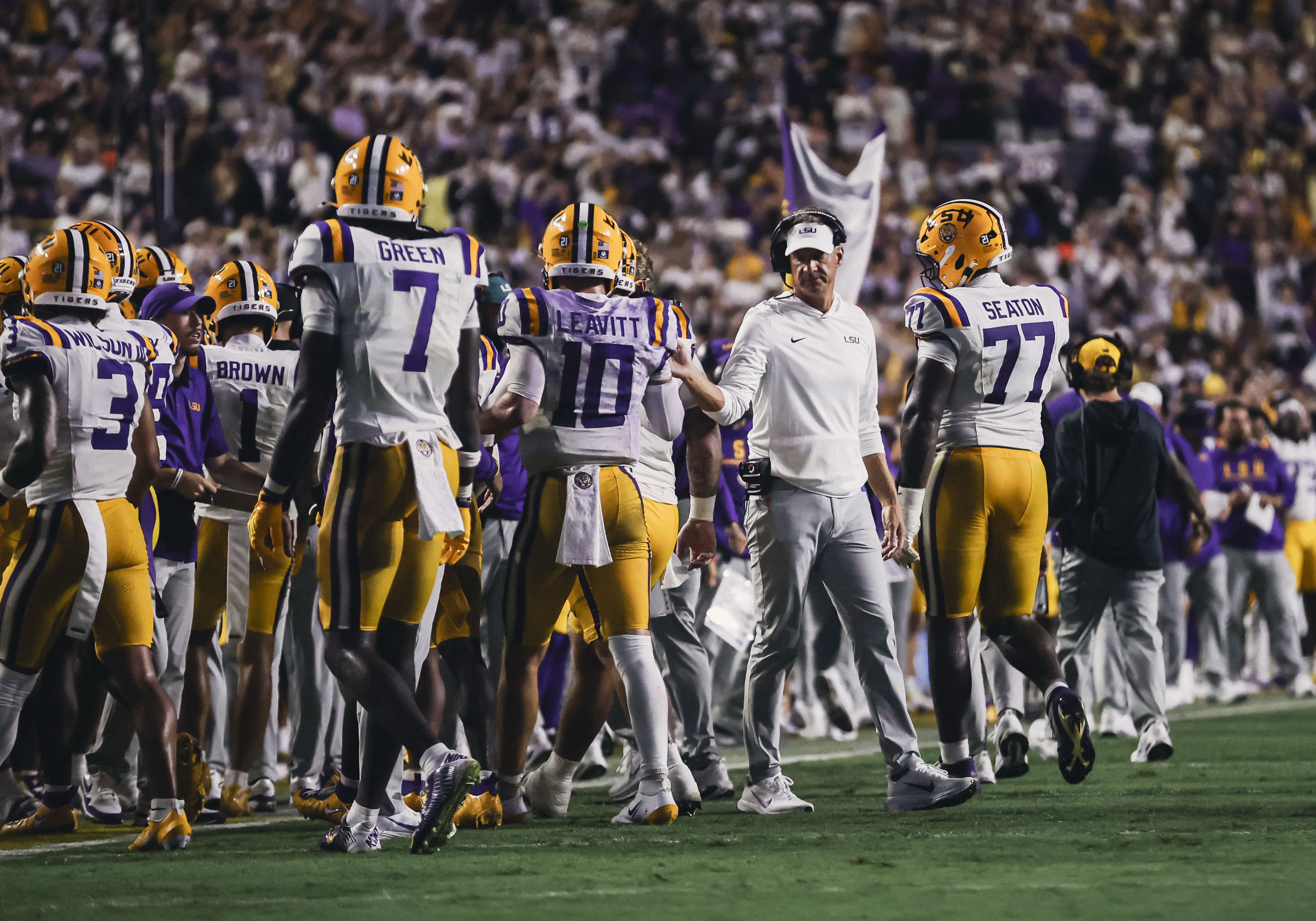 Lane Kiffin walks through an LSU Tigers huddle