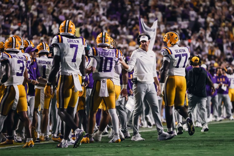 Lane Kiffin walks through an LSU Tigers huddle