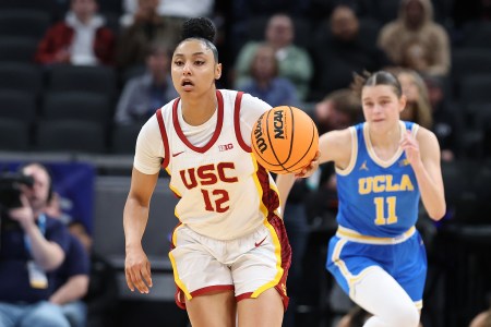 USC guard JuJu Watkins dribbles the ball with a UCLA defender in the background