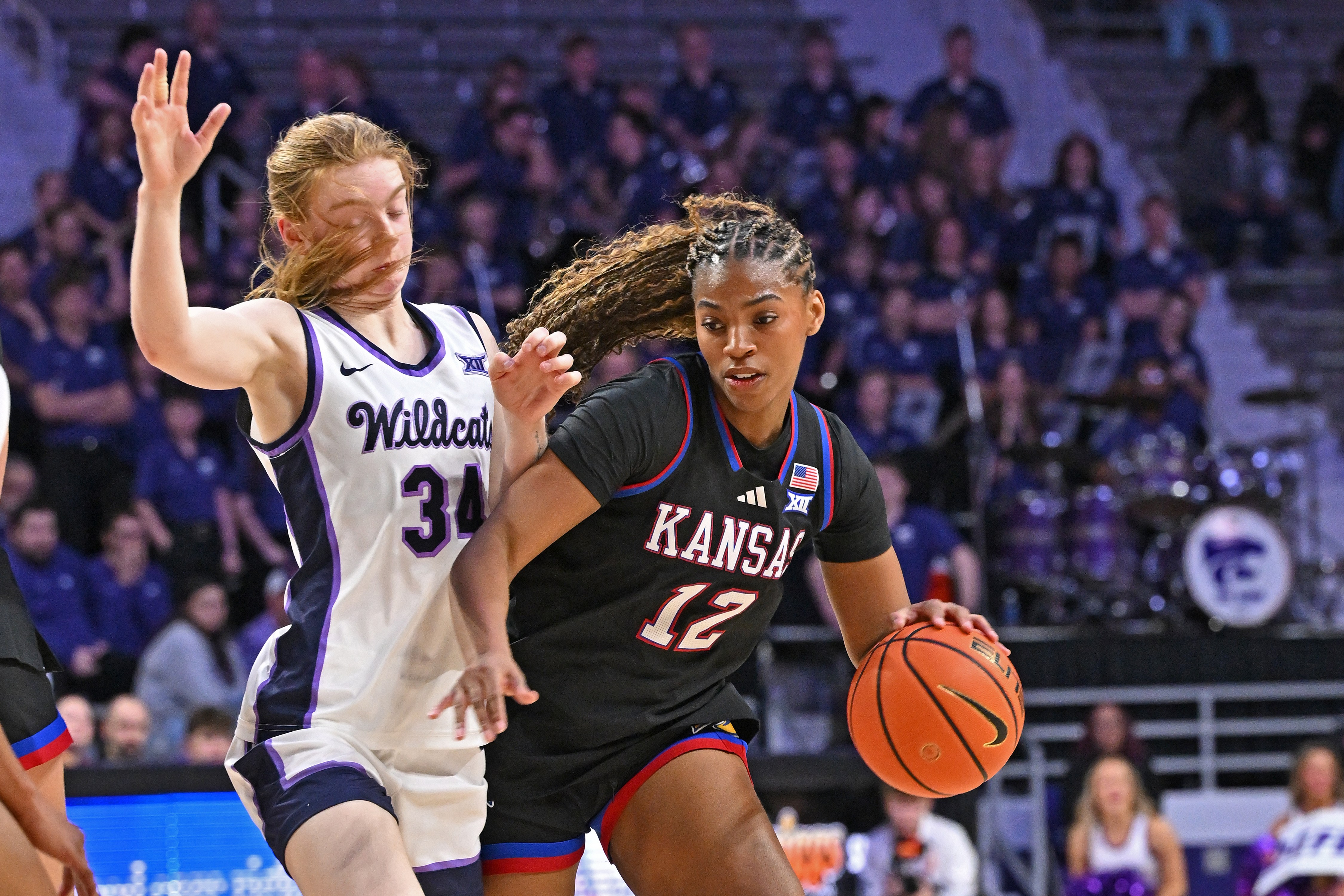 Kansas guard S’Mya Nichols attempting to drive past a Kansas State player