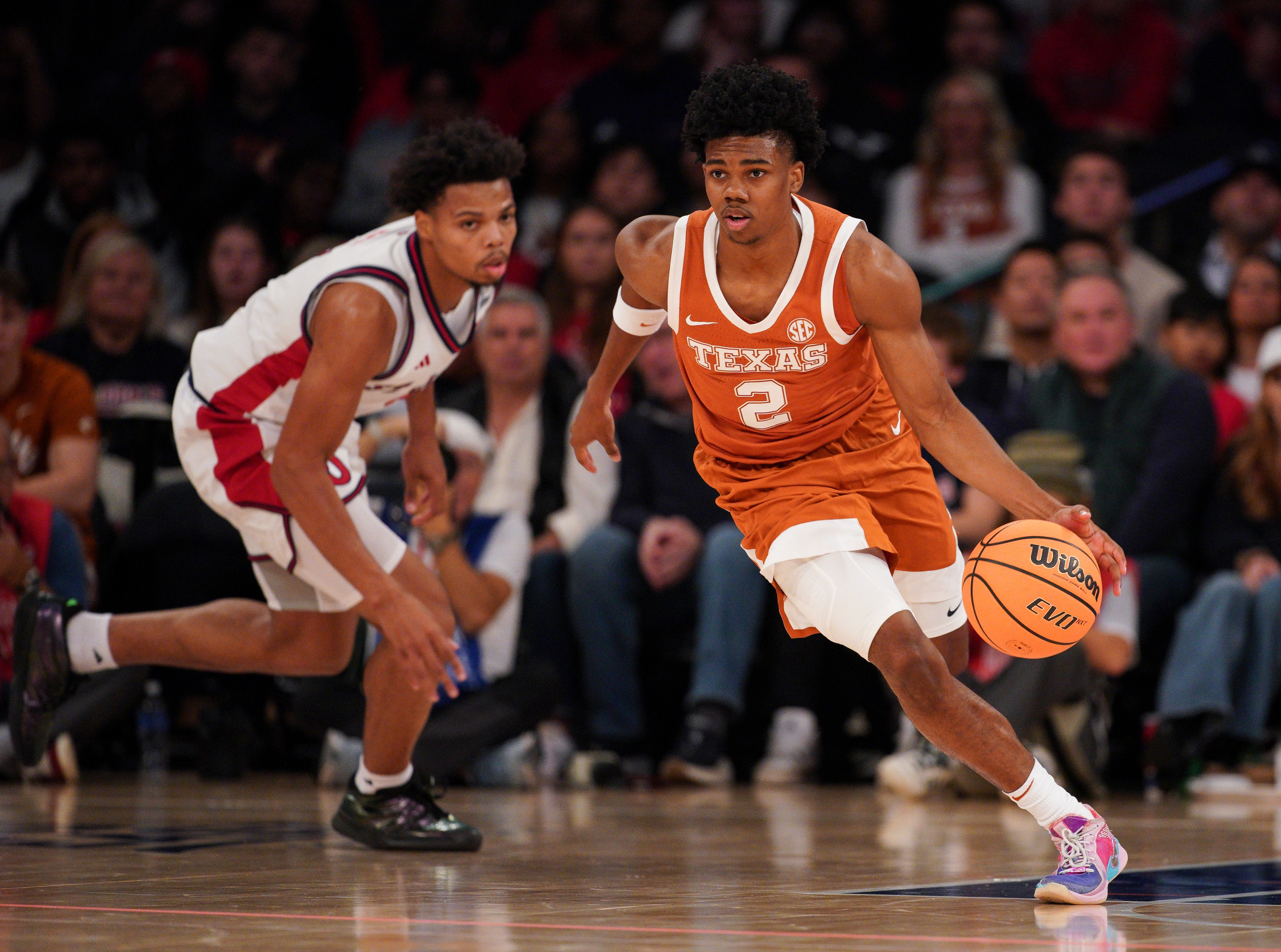 Texas guard Isaiah Johnson dribbles past a St. John's player